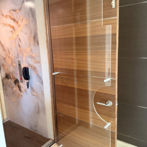 Full-door clear acrylic elevator guard with polished edges installed on a residential elevator.