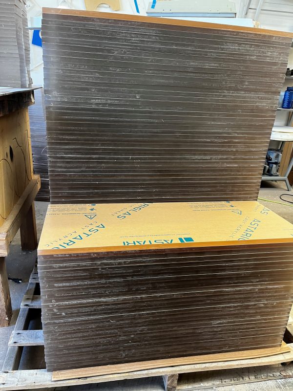 stack of 1/2 inch clear acrylic sheets cut into square blanks ready for fabrication
