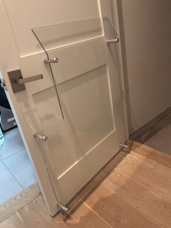 Standard 33-inch left-hand acrylic elevator door baffle installed on residential elevator landing door